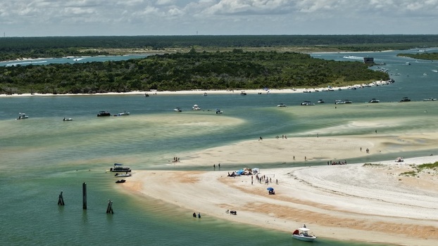Aerial view of Matanzas Inlet showing turquoise waters sandbars with people small boats and coastal vegetation in St. Johns County Florida United States. Aerial view of Matanzas Inlet showing turquoise waters sandbars with people small boats and coastal vegetation in St. Johns County Florida United States.