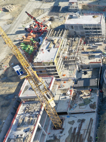 Aerial view of a large construction site featuring a yellow tower crane concrete building frames and workers on the ground Avcilar Istanbul Turkiye. Aerial view of a large construction site featuring a yellow tower crane concrete building frames and workers on the ground Avcilar Istanbul Turkiye.