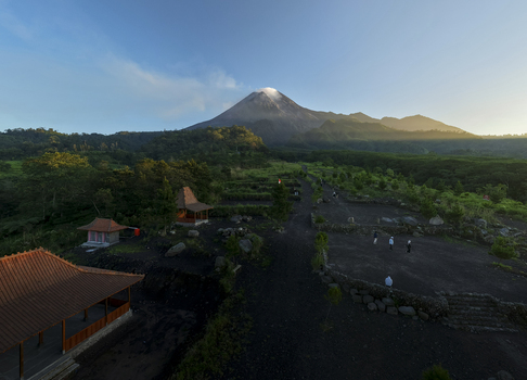 Aerial view of Bunker Kaliadem Merapi with traditional pavilions and people walking near the base of Mount Merapi volcano at sunrise Kecamatan Pakem Daerah Istimewa Yogya Indonesia. Aerial view of Bunker Kaliadem Merapi with traditional pavilions and people walking near the base of Mount Merapi volcano at sunrise Kecamatan Pakem Daerah Istimewa Yogya Indonesia.