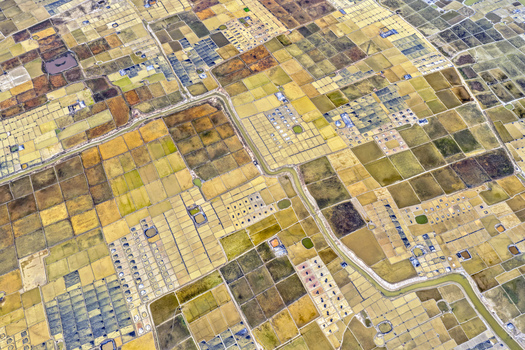 Aerial view of the patchwork of rice paddies creating a mosaic of earthy tones and textures divided by narrow waterways Cox s Bazar Chittagong Division Bangladesh. Aerial view of the patchwork of rice paddies creating a mosaic of earthy tones and textures divided by narrow waterways Cox s Bazar Chittagong Division Bangladesh.