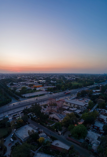 Aerial view of the urban landscape featuring the Arfa Kareem Tower at sunset with a busy highway residential rooftops and lush green trees in Lahore Punjab Pakistan. Aerial view of the urban landscape featuring the Arfa Kareem Tower at sunset with a busy highway residential rooftops and lush green trees in Lahore Punjab Pakistan.