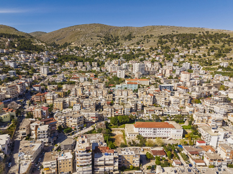 Aerial view of the coastal city of Saranda with its dense residential buildings and urban landscape nestled against rolling hills in Saranda Vlore County Albania. Aerial view of the coastal city of Saranda with its dense residential buildings and urban landscape nestled against rolling hills in Saranda Vlore County Albania.