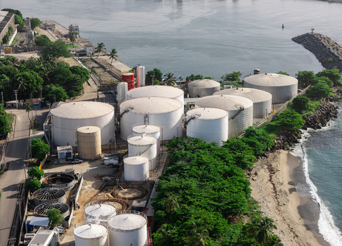 Aerial view of the industrial storage tanks and refinery facilities located along the coastline in Bajos de Haina San Cristobal Provinc Dominican Republic.