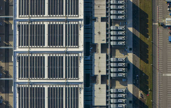 Aerial view of a digital data center facility with extensive solar panels on the roof and industrial cooling systems Netherlands. Aerial view of a digital data center facility with extensive solar panels on the roof and industrial cooling systems Netherlands.