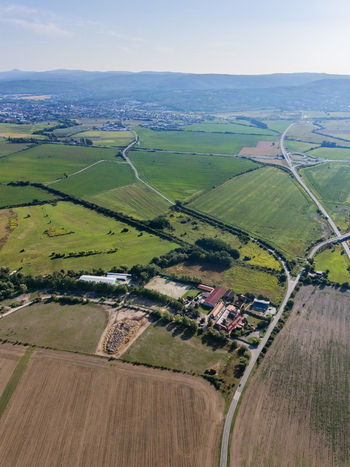 Aerial view of Polny mlyn farm complex surrounded by green agricultural fields and winding roads near Bratislava Bratislavsky kraj Slovakia. Aerial view of Polny mlyn farm complex surrounded by green agricultural fields and winding roads near Bratislava Bratislavsky kraj Slovakia.