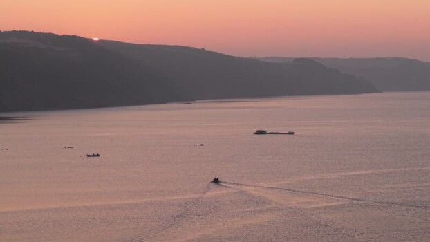 Aerial view of a boat sailing on calm water at sunset United Kingdom. Aerial view of a boat sailing on calm water at sunset United Kingdom.