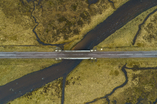 Aerial view of River Etive Bridge crossing a dark winding river surrounded by the rugged yellow green moorland of the Highlands in Ballachulish Scotland United Kingdom. Aerial view of River Etive Bridge crossing a dark winding river surrounded by the rugged yellow green moorland of the Highlands in Ballachulish Scotland United Kingdom.