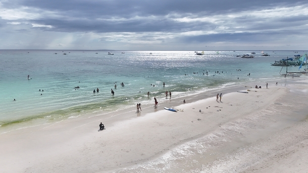 Malay Philippines 02 May 2026 Aerial view of Boracay Island with people on the white sand beach and turquoise water under a cloudy sky.