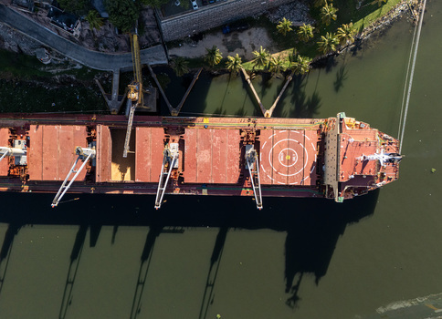 Aerial view of a large cargo ship docked on the Rio Ozama featuring cranes and a helipad on the deck in Santo Domingo Santo Domingo Dominican Republic.