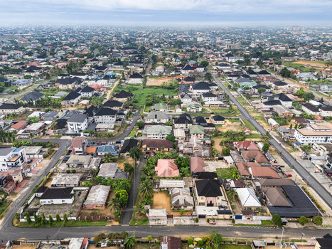 Aerial view of a sprawling residential cityscape under a soft overcast sky revealing a tapestry of dark roofs verdant trees and dusty roads Uyo Akwa Ibom Nigeria. Aerial view of a sprawling residential cityscape under a soft overcast sky revealing a tapestry of dark roofs verdant trees and dusty roads Uyo Akwa Ibom Nigeria.
