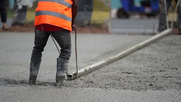 View of a worker leveling concrete on a construction site Bangladesh. View of a worker leveling concrete on a construction site Bangladesh.