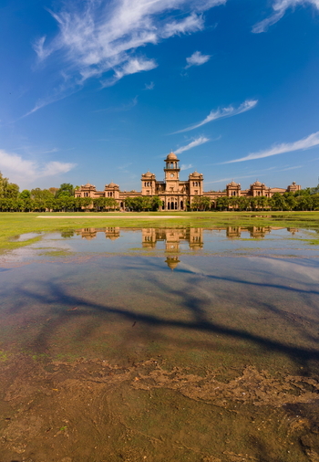 Aerial view of Islamia College University Peshawar with its historic architecture reflected in a flooded lawn under a clear blue sky in Peshawar Khyber Pakhtunkhwa Pakistan. Aerial view of Islamia College University Peshawar with its historic architecture reflected in a flooded lawn under a clear blue sky in Peshawar Khyber Pakhtunkhwa Pakistan.