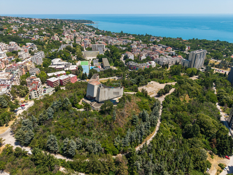 Aerial view of the Monument of the Bulgarian Soviet Friendship surrounded by lush greenery urban residential buildings and the Black Sea coastline in Varna Varna Bulgaria.