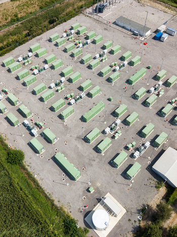 Aerial view of a modern battery energy storage system installation with rows of green containers electrical infrastructure and gravel ground in Tavazzano con Villavesco Lombardy Italy.