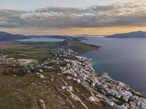 Aerial view of Saranda coastal town with buildings hills and the Ionian Sea at sunset in Saranda Vlore County Albania. Aerial view of Saranda coastal town with buildings hills and the Ionian Sea at sunset in Saranda Vlore County Albania.