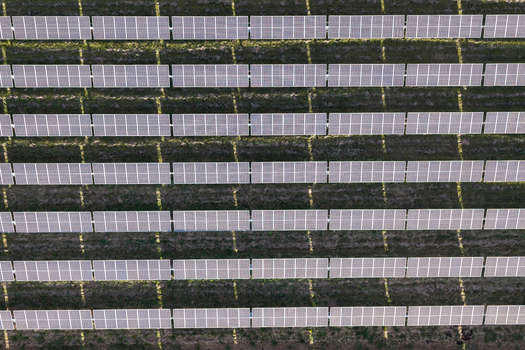 Aerial view of rows of solar panels installed in a field with long shadows cast on the ground in Woodburn Oregon United States. Aerial view of rows of solar panels installed in a field with long shadows cast on the ground in Woodburn Oregon United States.