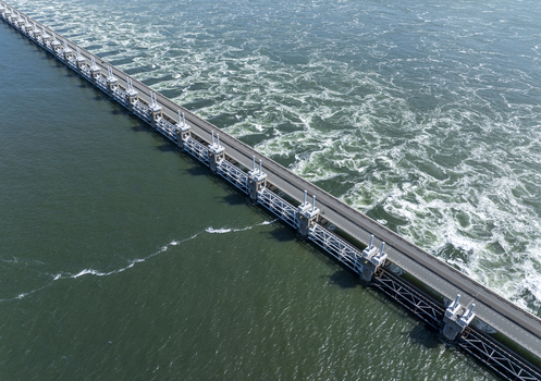 Aerial view of the Eastern Scheldt Storm Surge Barrier with turbulent water flowing through the sluice gates in Vrouwenpolder Zeeland Netherlands. Aerial view of the Eastern Scheldt Storm Surge Barrier with turbulent water flowing through the sluice gates in Vrouwenpolder Zeeland Netherlands.