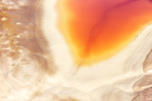Aerial view of the vibrant red and orange acidic waters of the Rio Tinto river flowing through the mineral rich landscape of Minas de Riotinto Andalusia Spain.