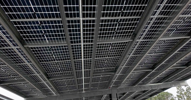 Aerial view of the underside of a solar panel structure with photovoltaic modules mounted on a metal frame in Long Beach California United States. Aerial view of the underside of a solar panel structure with photovoltaic modules mounted on a metal frame in Long Beach California United States.