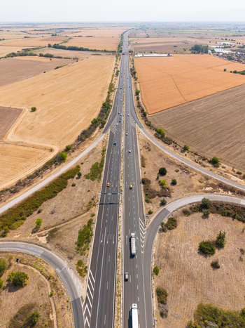 Aerial view of Highway Trakiya with vehicles driving through agricultural fields in Bulgaria. Aerial view of Highway Trakiya with vehicles driving through agricultural fields in Bulgaria.