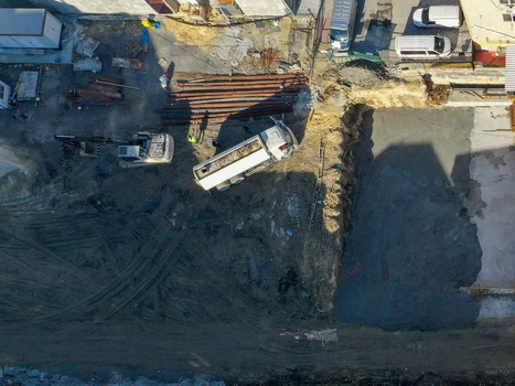 Aerial view of a construction site with an excavator a white truck and a deep foundation pit during ground works in Istanbul Istanbul Turkiye.