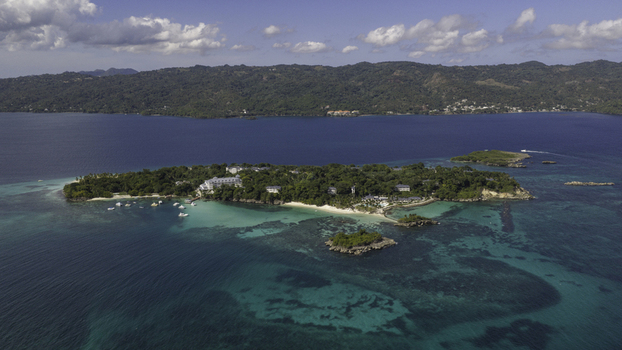 Aerial view of Cayo Levantado Beach with turquoise waters lush tropical vegetation white sand and resort buildings surrounded by the Caribbean Sea in Samana Samana Dominican Republic. Aerial view of Cayo Levantado Beach with turquoise waters lush tropical vegetation white sand and resort buildings surrounded by the Caribbean Sea in Samana Samana Dominican Republic.