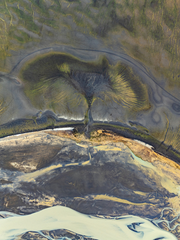 Aerial view of the volcanic landscape of Landmannalaugar with dark soil mossy green slopes and winding river channels in Rangarthing ytra Iceland. Aerial view of the volcanic landscape of Landmannalaugar with dark soil mossy green slopes and winding river channels in Rangarthing ytra Iceland.