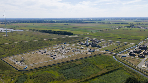 Aerial view of the Gasunie and Air Products nitrogen factory surrounded by green fields industrial infrastructure and a wind turbine in Muntendam Groningen Netherlands.