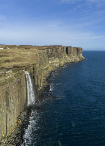 Aerial view of Kilt Rock and Mealt Falls with water plunging from basalt cliffs into the blue sea Isle of Skye Scotland United Kingdom. Aerial view of Kilt Rock and Mealt Falls with water plunging from basalt cliffs into the blue sea Isle of Skye Scotland United Kingdom.
