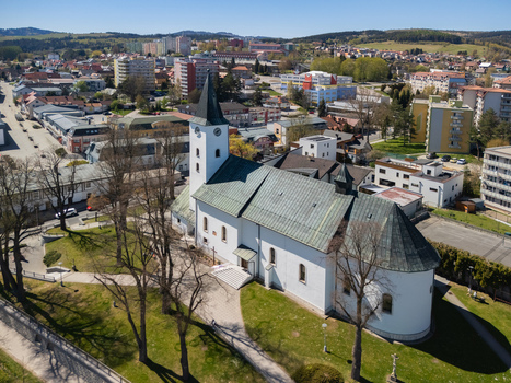 Aerial view of the Roman Catholic Church of Saints Simon and Jude with its white facade and black spire overlooking the town buildings Namestovo Zilina Region Slovakia. Aerial view of the Roman Catholic Church of Saints Simon and Jude with its white facade and black spire overlooking the town buildings Namestovo Zilina Region Slovakia.