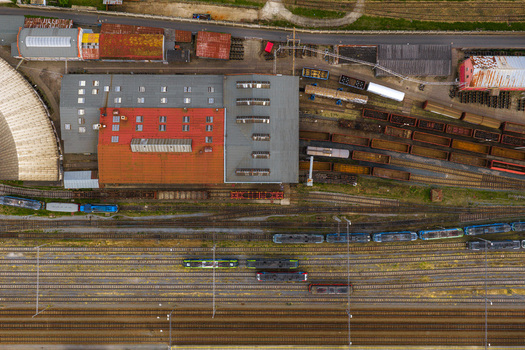 Aerial view of a railway yard featuring multiple tracks stationary trains and industrial buildings with red and grey roofs in Breclav South Moravian Region Czechia.