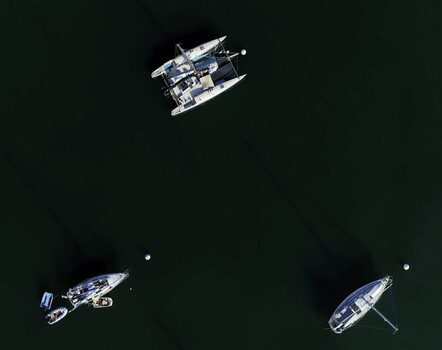 Aerial view of sailboats moored on the calm dark water in San Diego California United States.