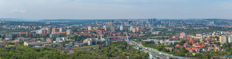Aerial view of the sprawling cityscape featuring residential districts industrial zones and a highway under a clear blue sky Prague Prague Czechia.