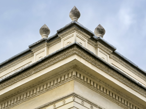 View of the ornate stone corner of a neoclassical building featuring decorative finials against a soft overcast sky Sariyer Istanbul Turkiye.