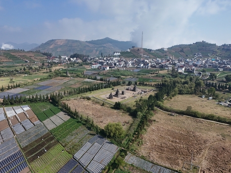 Aerial view of Arjuna Temple surrounded by agricultural fields and the town of Kecamatan Batur in the Dieng Plateau Jawa Tengah Indonesia.