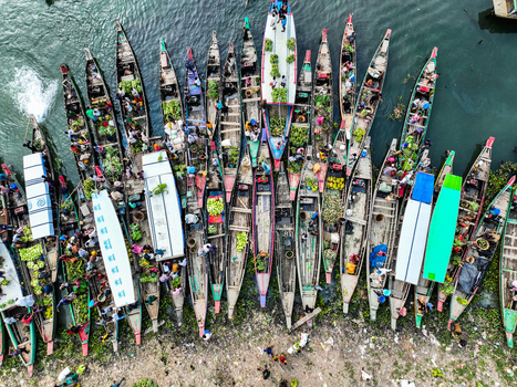 Rangamati Hill District Bangladesh 18 May 2024 Aerial view of Kaptai Lake filled with wooden boats carrying produce and people showcasing vibrant local market activity.