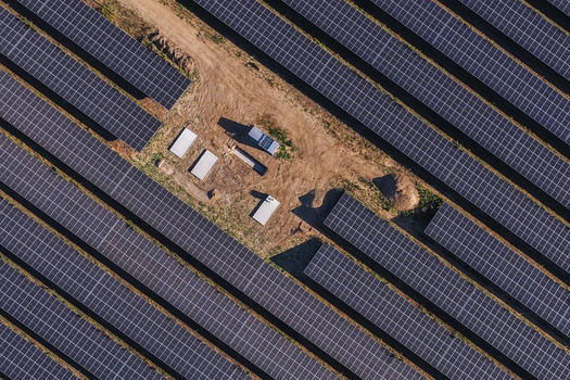 Aerial view of a large solar farm with rows of photovoltaic panels and a small maintenance area in Uckermark Brandenburg Germany. Aerial view of a large solar farm with rows of photovoltaic panels and a small maintenance area in Uckermark Brandenburg Germany.