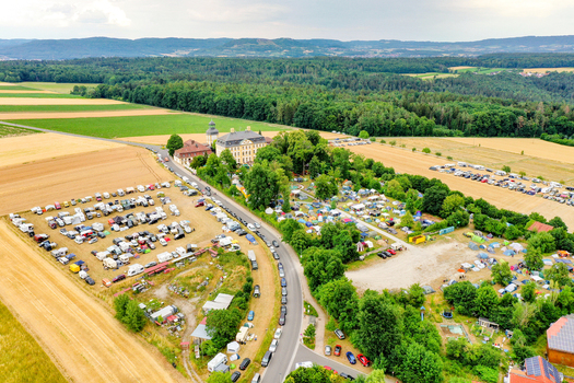 Aerial view of Schloss Jagersburg surrounded by a large campsite with tents and parked vehicles in the countryside of Eggolsheim Bayern Germany. Aerial view of Schloss Jagersburg surrounded by a large campsite with tents and parked vehicles in the countryside of Eggolsheim Bayern Germany.