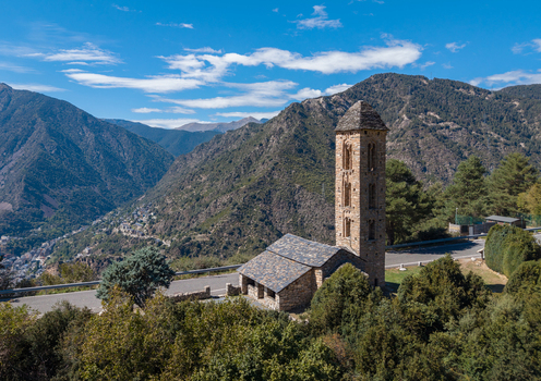 Aerial view of the historic Sant Miquel Engolasters church with its stone bell tower set against a backdrop of green mountains in Engolasters Escaldes Engordany Andorra. Aerial view of the historic Sant Miquel Engolasters church with its stone bell tower set against a backdrop of green mountains in Engolasters Escaldes Engordany Andorra.