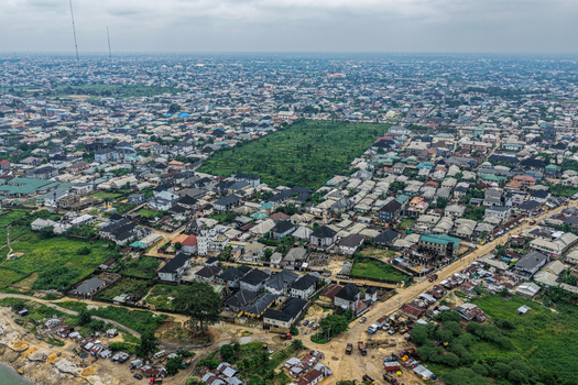 Port Harcourt Nigeria 03 July 2026 Aerial view of the urban landscape of Port Harcourt featuring dense residential housing green spaces and unpaved roads under a cloudy sky. Port Harcourt Nigeria 03 July 2026 Aerial view of the urban landscape of Port Harcourt featuring dense residential housing green spaces and unpaved roads under a cloudy sky.