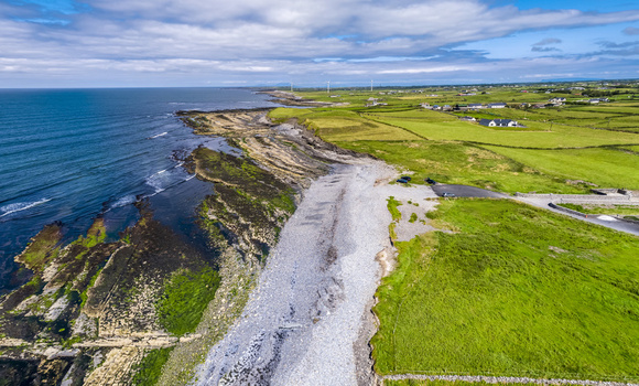 Aerial view of the rugged coastline and green fields featuring rocky shores lush pastures and the Atlantic Ocean in Enniscrone County Sligo Ireland. Aerial view of the rugged coastline and green fields featuring rocky shores lush pastures and the Atlantic Ocean in Enniscrone County Sligo Ireland.
