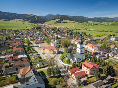 Aerial view of the historic village featuring St. Matthew s Church traditional red roofed houses and rolling green hills under a clear sky Partizanska Lupca Zilina Region Slovakia. Aerial view of the historic village featuring St. Matthew s Church traditional red roofed houses and rolling green hills under a clear sky Partizanska Lupca Zilina Region Slovakia.