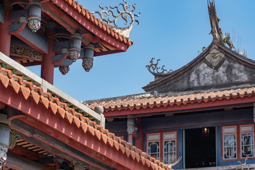 View of the ornate traditional roof architecture of Chihkan Tower with intricate terracotta tiles and decorative ridges against a clear blue sky in Chihkan Village Tainan City Taiwan. View of the ornate traditional roof architecture of Chihkan Tower with intricate terracotta tiles and decorative ridges against a clear blue sky in Chihkan Village Tainan City Taiwan.