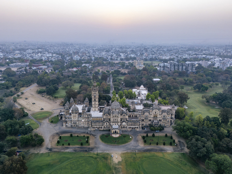 Vadodara India 14 March 2026 Aerial view of the majestic Laxmi Vilas Palace featuring its iconic Indo Saracenic architecture sprawling green gardens and a hazy city skyline during sunset. Vadodara India 14 March 2026 Aerial view of the majestic Laxmi Vilas Palace featuring its iconic Indo Saracenic architecture sprawling green gardens and a hazy city skyline during sunset.