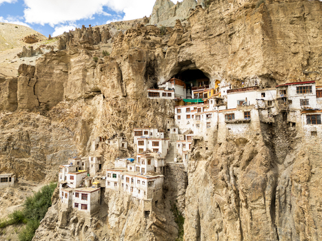 Aerial view of Phukthal Gompa built into the rugged cliffside with traditional white buildings and cave monastery in Phukthal Ladakh India.