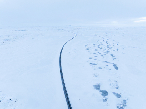 Aerial view of a winding road cutting through a vast snow covered landscape in Egilsstadir Mulathing Iceland. Aerial view of a winding road cutting through a vast snow covered landscape in Egilsstadir Mulathing Iceland.