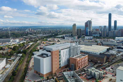 Aerial view of a modern data center building with brick and white facade situated near railway tracks and an urban landscape in the United Kingdom. Aerial view of a modern data center building with brick and white facade situated near railway tracks and an urban landscape in the United Kingdom.