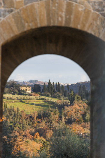 View of the rolling hills and cypress trees of the Tuscan countryside framed by a stone archway Monteriggioni Tuscany Italy. View of the rolling hills and cypress trees of the Tuscan countryside framed by a stone archway Monteriggioni Tuscany Italy.
