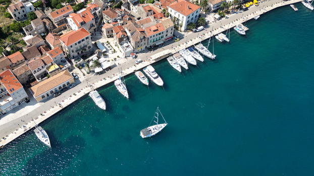 Aerial view of the historic waterfront with yachts and sailboats docked along the stone promenade in the town of Vis Split Dalmatia County Croatia. Aerial view of the historic waterfront with yachts and sailboats docked along the stone promenade in the town of Vis Split Dalmatia County Croatia.
