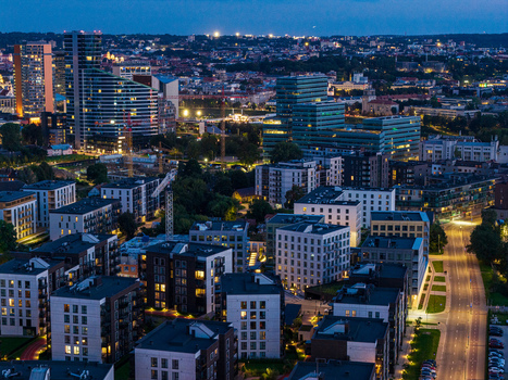 Aerial view of the modern skyline of Vilnius featuring contemporary office buildings residential apartment blocks and illuminated streets at twilight in Vilnius Vilnius County Lithuania. Aerial view of the modern skyline of Vilnius featuring contemporary office buildings residential apartment blocks and illuminated streets at twilight in Vilnius Vilnius County Lithuania.